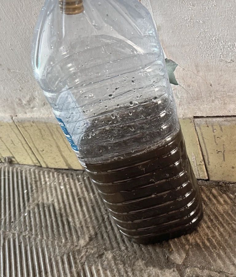 Agua con suciedad recogida durante un mantenimiento de aire acondicionado